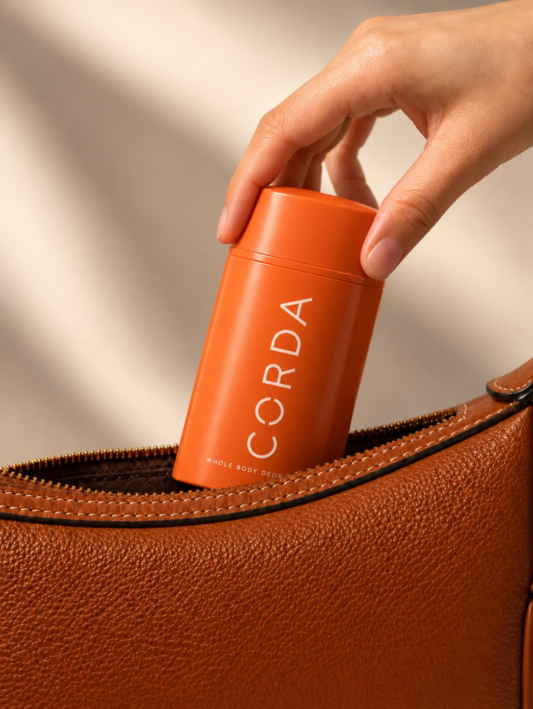 A persimmon stick being dropped into a handbag