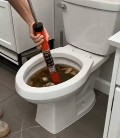 A clogged toilet draining after a few pushes